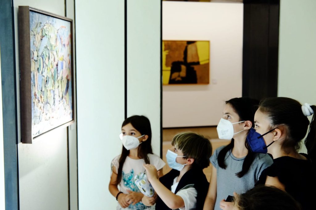 Foto di bambini che guardano un'opera d'arte all'interno di un Museo