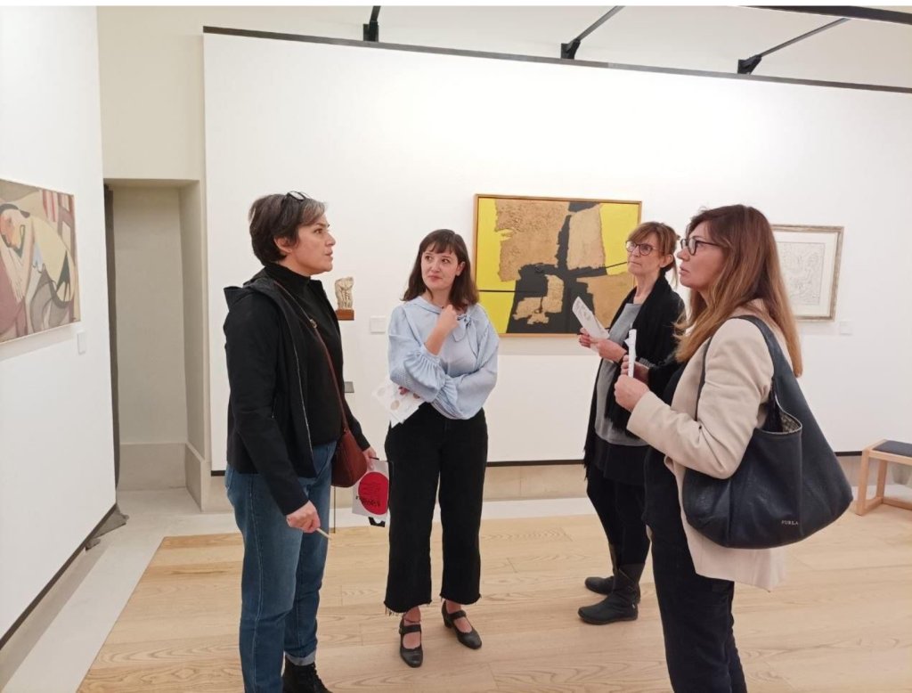 Foto di 4 donne che conversano mentre osservano le opere esposte in fondazione